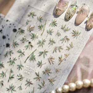 Close-up of MS-857 bamboo leaf nail decals with gold trim and metallic finish