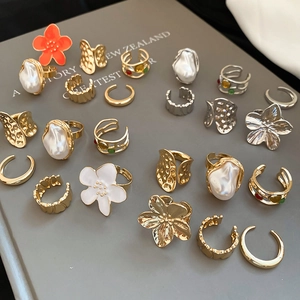 Close-up of vintage gold and silver rings with floral patterns and baroque pearls