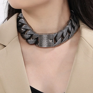 Close-up of textured dark silver Cuban link chain necklace with secure clasp on a model