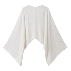 Flat lay of white batwing sleeve blouse showing loose fit and textured linen fabric