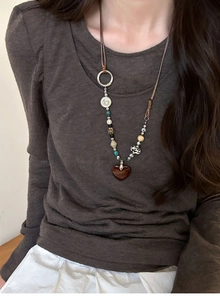 Detail of bohemian beaded necklace featuring mixed stone beads and a red heart pendant