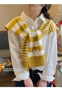 Detail of yellow and white striped knit shawl with a premium woven label and ribbed edges