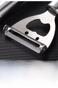Detail of mirror-polished stainless steel peeler with thickened handle and sharp serrated blade