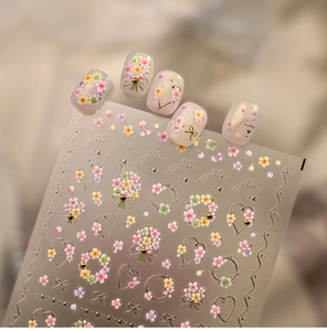 Macro detail of embossed floral nail art stickers with gold foil and flower patterns