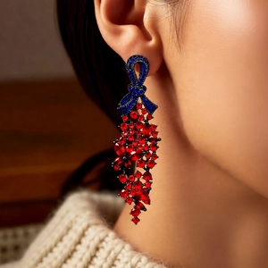 Gros plan sur des boucles d'oreilles nœud vintage avec cristaux rouges et bleus et glands