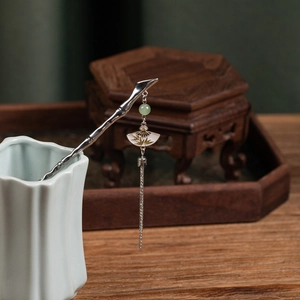 Detail of vintage silver hair pin with bamboo texture, green beads and fan tassel