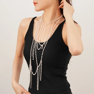 Close-up of a multi-layer glass pearl body chain worn by a model in luxury style