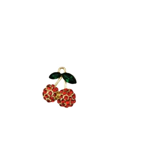 Sweet red cherry pendant with green zircon inlay and gold-plated frame on white background