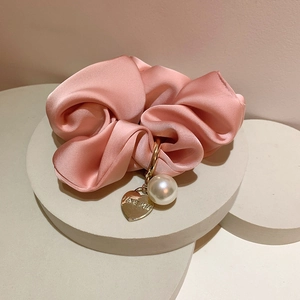 Pink silk scrunchie with a gold heart charm and large pearl detail for hair