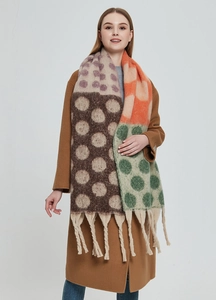 Dettaglio di una sciarpa in maglia spessa con pois colorati e lunghe frange