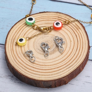 DIY jewelry set with silver lobster clasps and colorful evil eye bead chains on wood