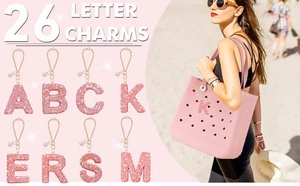 Macro detail of pink rhinestone initial charms with golden chains for bags and cups