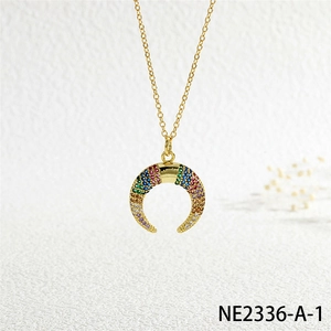 Macro shot of gold horn pendant with multi-color micro-paved zircons on a fine chain