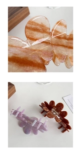 Detailed macro view of large acetate petal hair clips with amber and purple textures