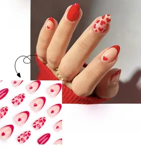 Close-up of red heart press-on nails in short almond shape featuring French tip design