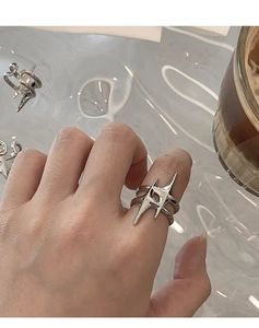 Close-up of a silver star open ring worn on finger with a casual lifestyle background