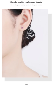 Close-up of a round pink zircon stud earring with a silver screw-back on a model ear