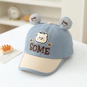 Detail of baby baseball cap featuring cute bear patches and 3D ears in blue and beige
