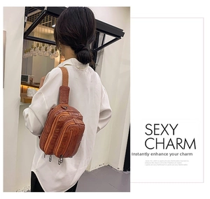 Sac de poitrine marron texture crocodile avec trois zips et bandoulière sur un modèle