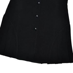 Close-up of black sleeveless dress featuring tailored buttons and side pleated details