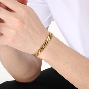 Close-up of golden woven mesh chain bracelet on wrist showing refined texture