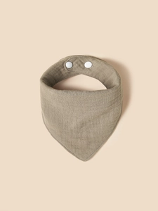 Close-up of muslin cotton baby bib in taupe with texture detail and snap fasteners