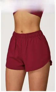 Détail du short de sport rouge cerise à taille haute avec ceinture élastique et fentes