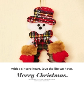 Detailed view of plush Christmas doll ornament with red tartan plaid hat and bowtie