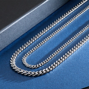 Macro view of polished silver titanium steel curb chain necklace on a dark background