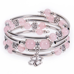 Detailed shot of pink beaded multi-layer bracelet with rose accents and clover charm