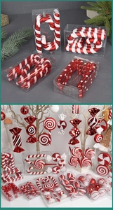 Close-up of red and white striped Christmas candy cane ornaments and festive lollipop baubles