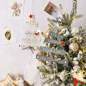 Close-up of wooden Christmas tree ornaments with bird and bow on a festive tree