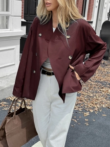 Detail view of burgundy double-breasted jacket with buttons in casual street style