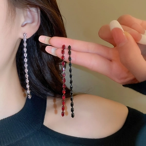 Dettaglio di lunghi orecchini a nappa con zircone marquise in rosa, rosso e nero