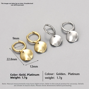 Detailed view of gold and silver irregular disc earrings with textured wave surface