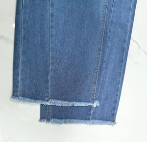 Detailopname van de denim jeanszoom met gerafelde rand en franjes op witte ondergrond