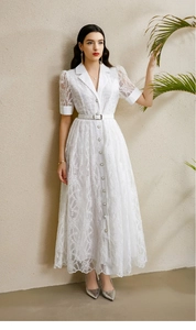 Détail de robe en dentelle blanche avec manches lanternes et jupe large brodée