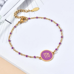 Detailed macro view of gold Virgo zodiac charm with purple enamel on stainless steel bracelet