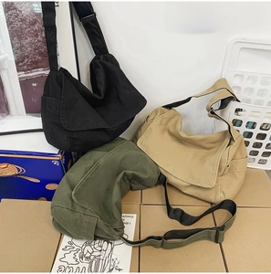 Three canvas messenger bags in black, khaki, and army green with adjustable straps