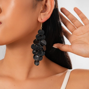 Close-up of black sequin long tassel drop earrings worn on a model's ear