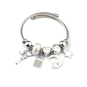 Detailed macro of silver charm bracelet featuring Valentine's heart and angel pendants