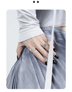Close-up of S925 silver flower ring with zircon pearls and woven silver band on finger