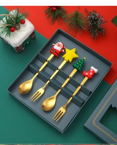 Close-up of 4-piece Christmas cutlery set with Santa and tree motifs in a gift box