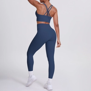 Dettaglio del set yoga blu navy che mostra il reggiseno sportivo incrociato e i leggings a vita alta