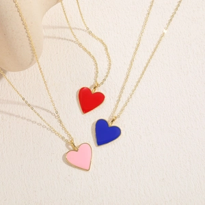 Detailed view of red, blue and pink enamel heart pendants on 14K gold plated chains