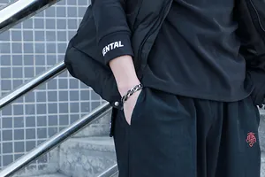 Gros plan d'un bracelet gourmette en acier inoxydable noir et argenté pour homme