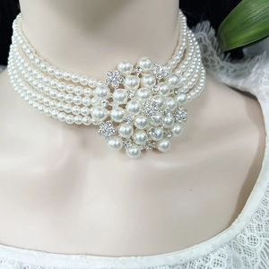 Detailed macro view of multilayer pearl choker featuring a crystal flower pendant