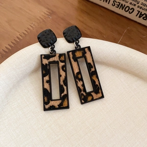 Détail de boucles d'oreilles léopard rectangulaires avec clous en métal noir martelé