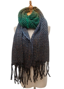 Close-up of green, blue, and black gradient knit shawl with textured tweed and fringed edges