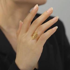 Minimalist gold stainless steel ring with hollow scroll pattern on a female model hand